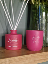 duftlys rosa og duftpinner på en eikehylle med en blomstervase i bakgrunnen