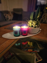 trefat på et bord, med 2 glasslys og en plante plassert på fatet